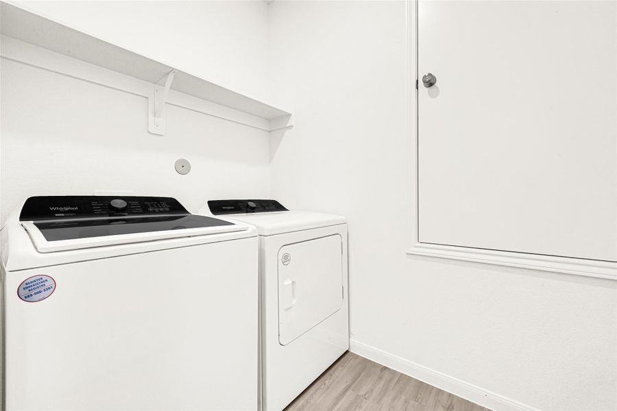 Practical indoor laundry room area with convenient overhead wire shelving for extra storage.