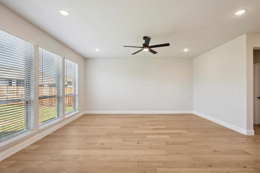 Unfurnished room featuring a ceiling fan, baseboards, recessed lighting, and light wood-type flooring