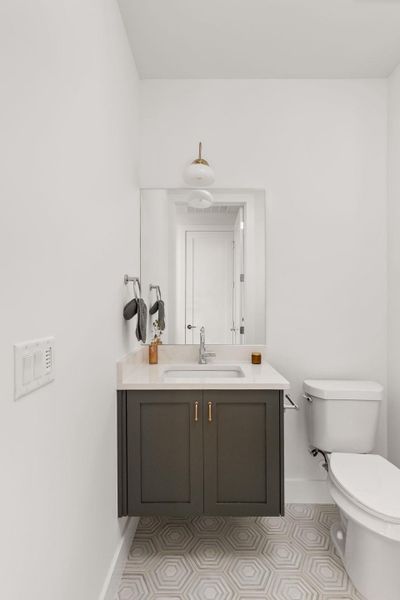 Half bath with vanity and light tile patterned floors