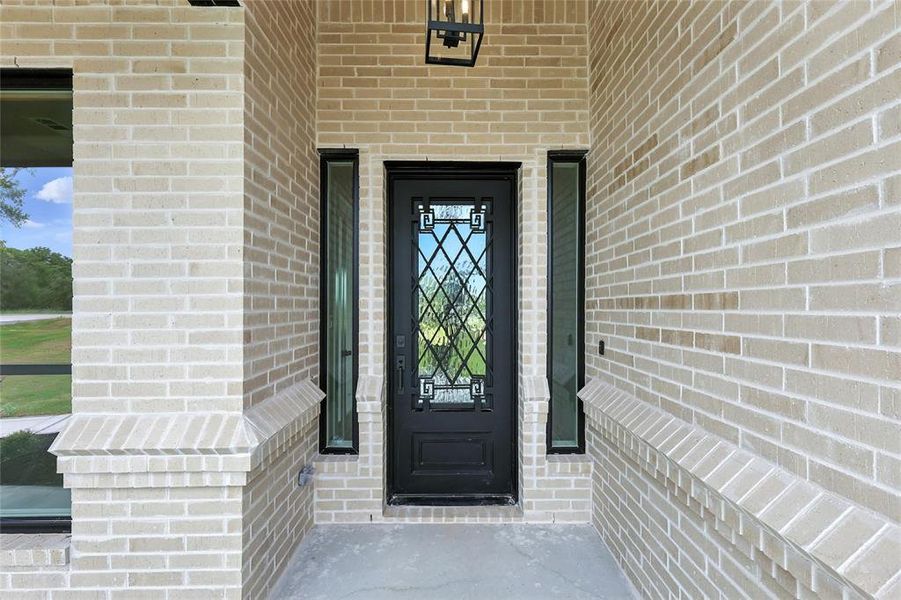 View of exterior entry featuring brick siding