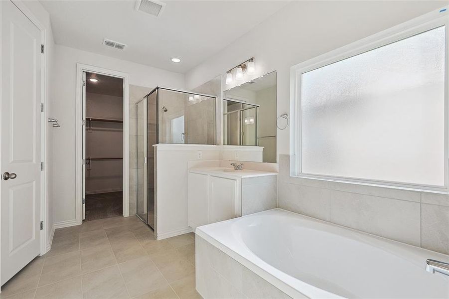 Bathroom featuring independent shower and bath, vanity, and tile patterned floors