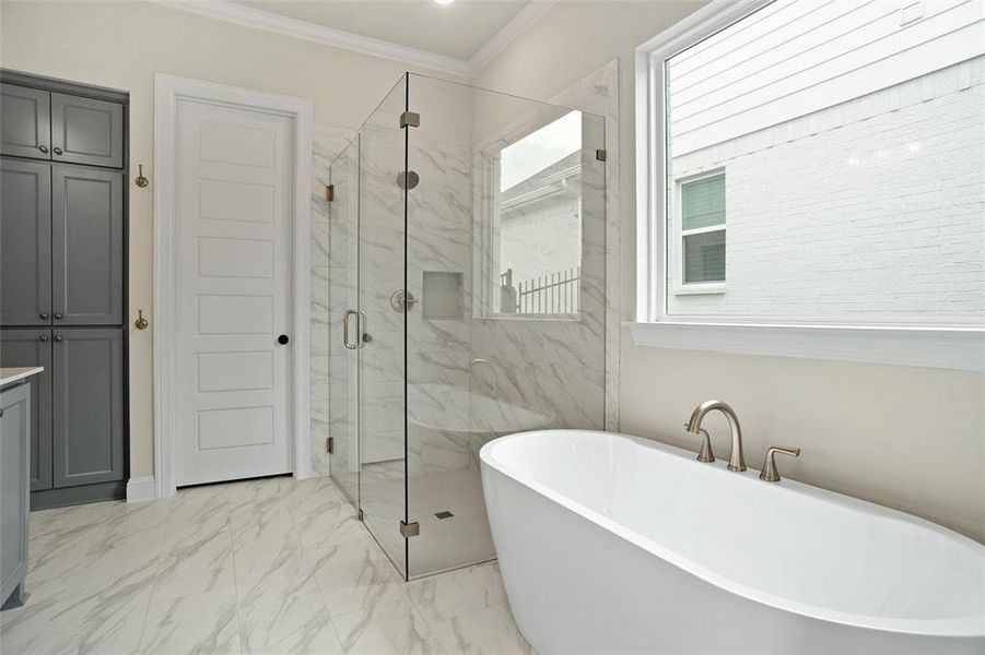 Bathroom featuring crown molding, tile patterned floors, and separate shower and tub