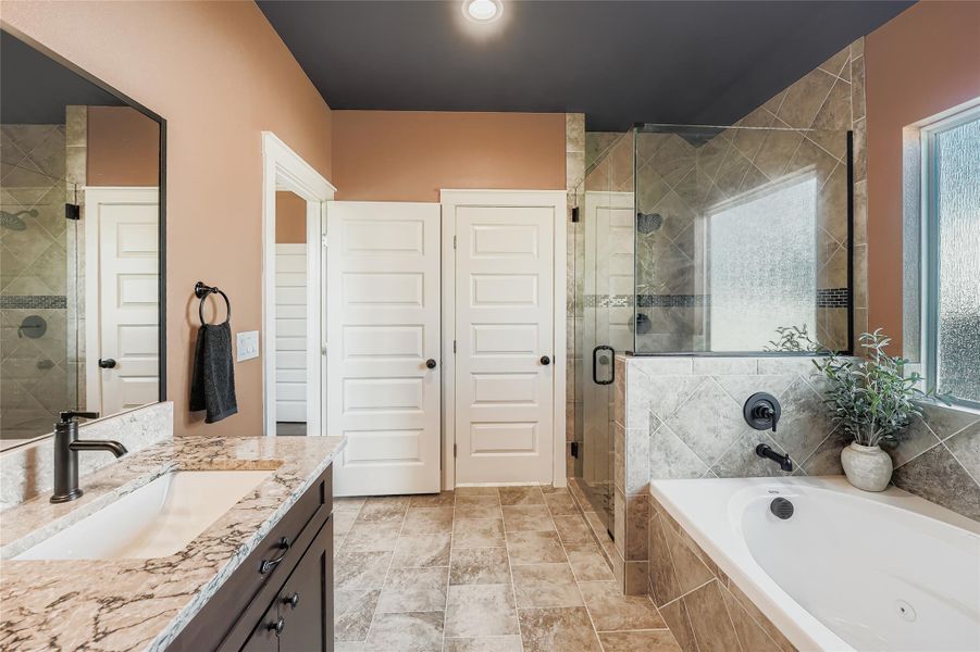 Full bathroom featuring vanity, a bath, and a shower stall