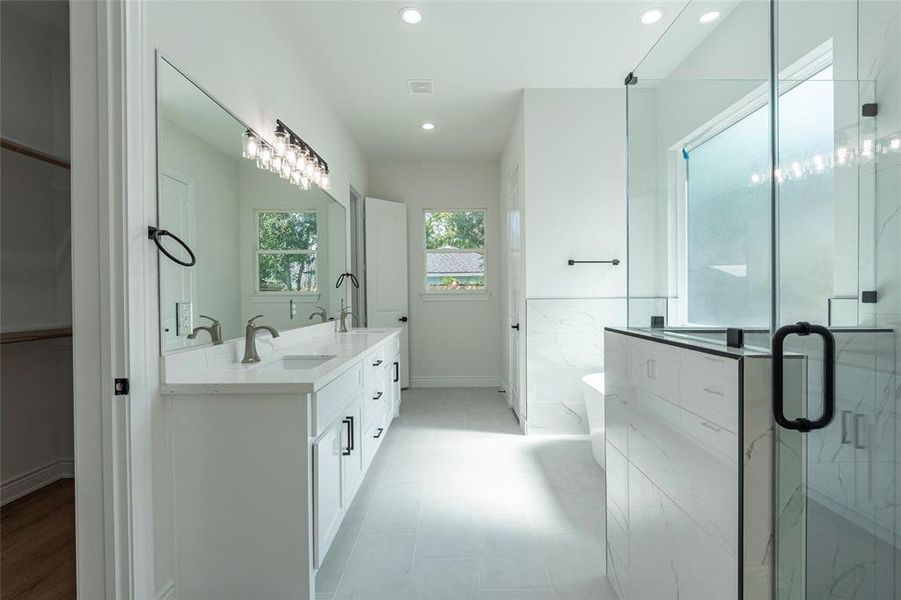 Primary bathroom offers double sinks, a walk in shower, and soaking tub