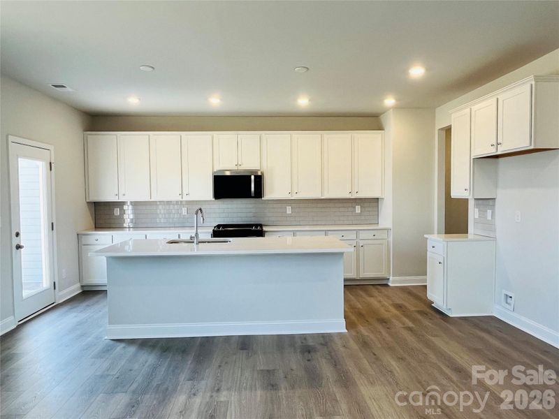 Kitchen with lots of cabinets, quartz and ss appliances