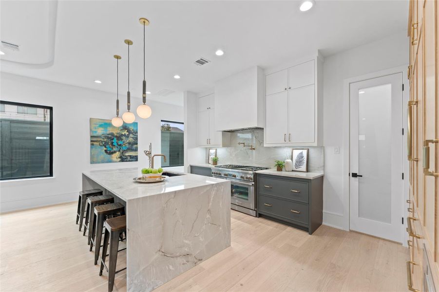 Oversized island with quartzite surfaces and seating.