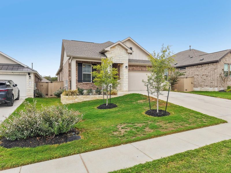View of front of home with stone siding, concrete driveway, a garage, a shingled roof, and board and batten siding View of front of home with stone siding, concrete driveway, a garage, a shingled roof, and board and batten siding