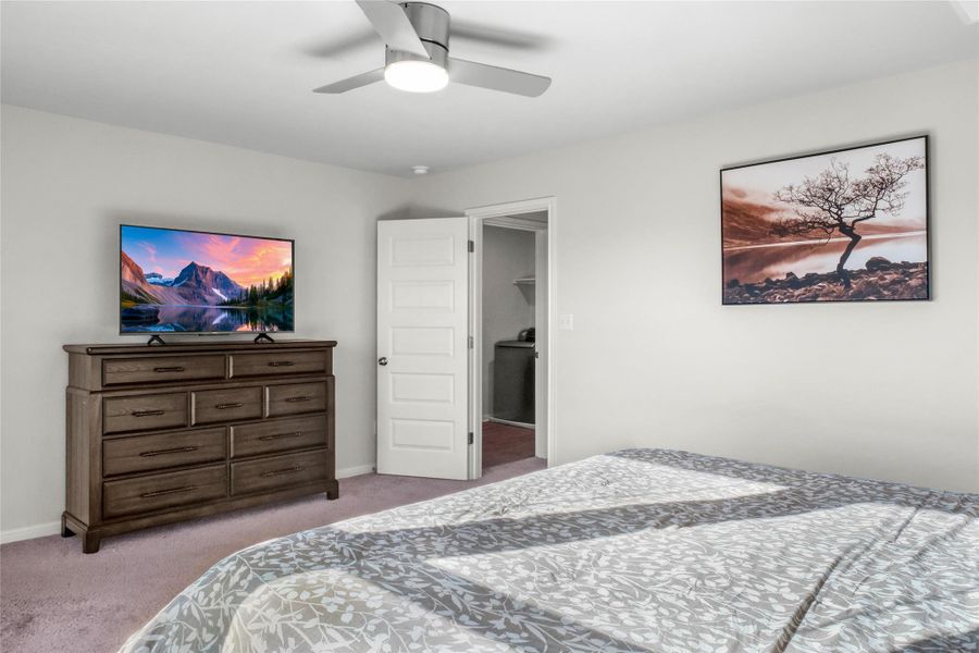 Bedroom with light colored carpet and a ceiling fan