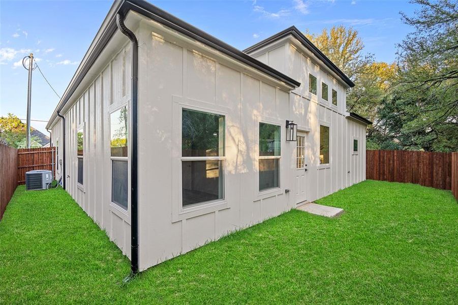 View of home's exterior featuring a lawn and cooling unit