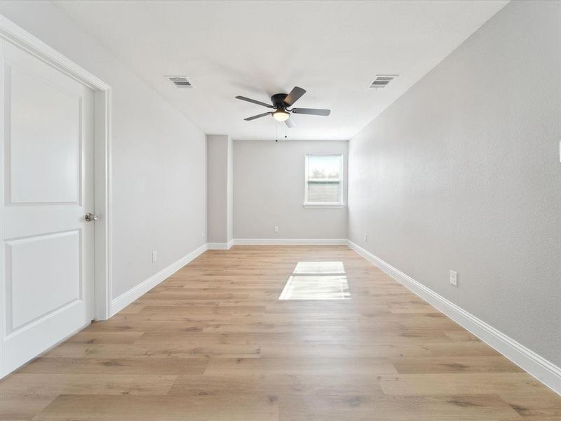 Empty room with ceiling fan and light hardwood / wood-style flooring