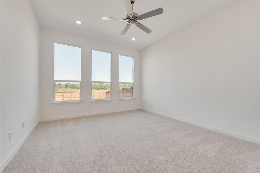 Carpeted spare room featuring ceiling fan