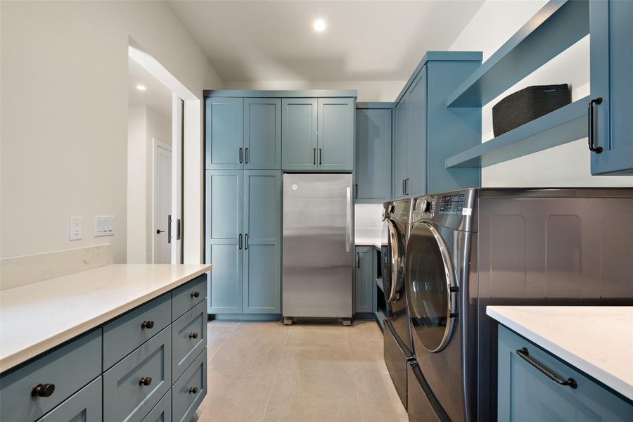 Laundry room with recessed lighting, washer and clothes dryer, light tile patterned flooring, and cabinet space