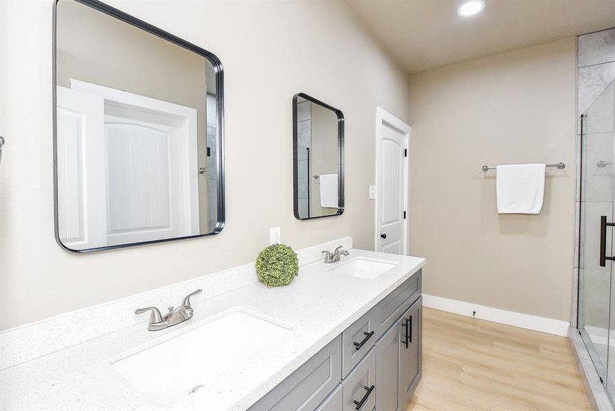 Primary En-Suite Bathroom with Double Sinks, Large Shower, and Walk-In Closet