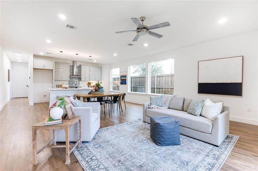 Living room with ceiling fan and light hardwood / wood-style floors