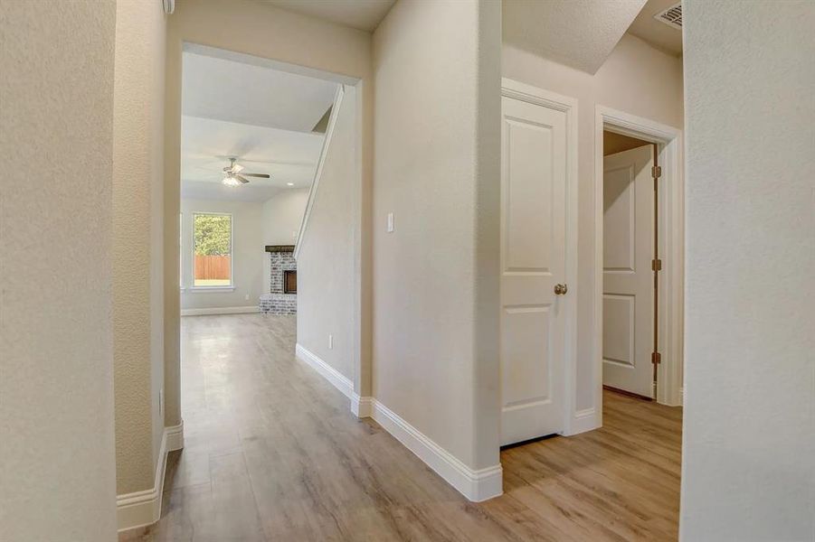 Hall with light wood-type flooring and baseboards