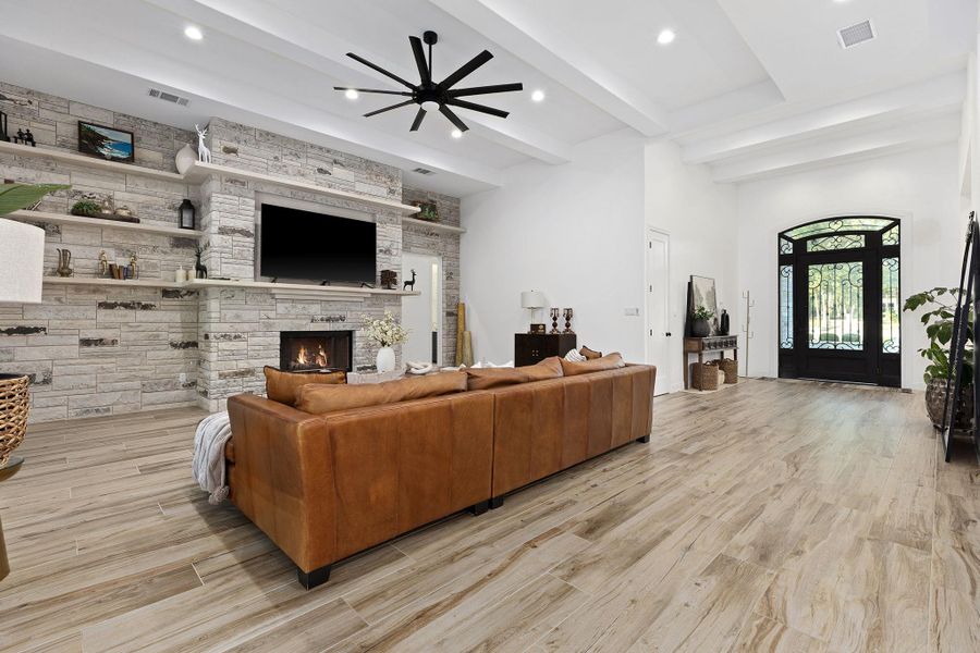 Living room with ceiling fan, a fireplace, beam ceiling, light wood finished floors, and recessed lighting Living room with ceiling fan, a fireplace, beam ceiling, light wood finished floors, and recessed lighting
