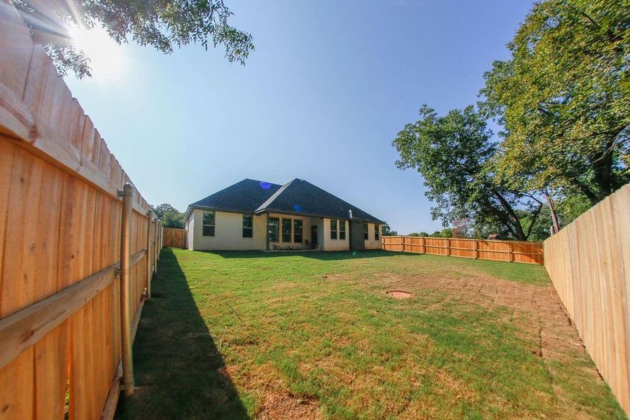 Back of property featuring a fenced backyard and a patio area Back of property featuring a fenced backyard and a patio area