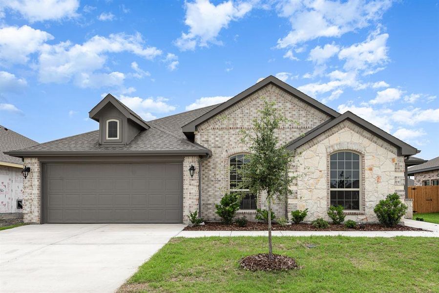 View of front of house featuring a garage and a front yard