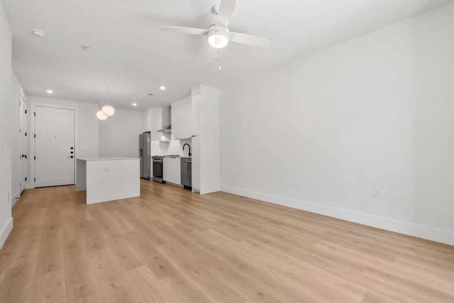 Unfurnished living room featuring ceiling fan, light wood-type flooring, and recessed lighting
