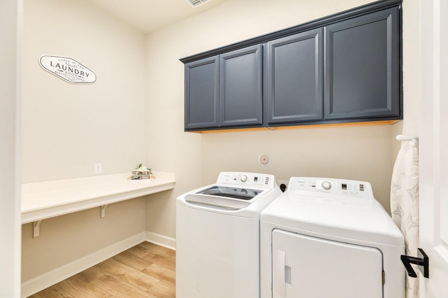 The laundry room, located off the mud room, has a large counter for folding clothes and plenty of space for storing supplies