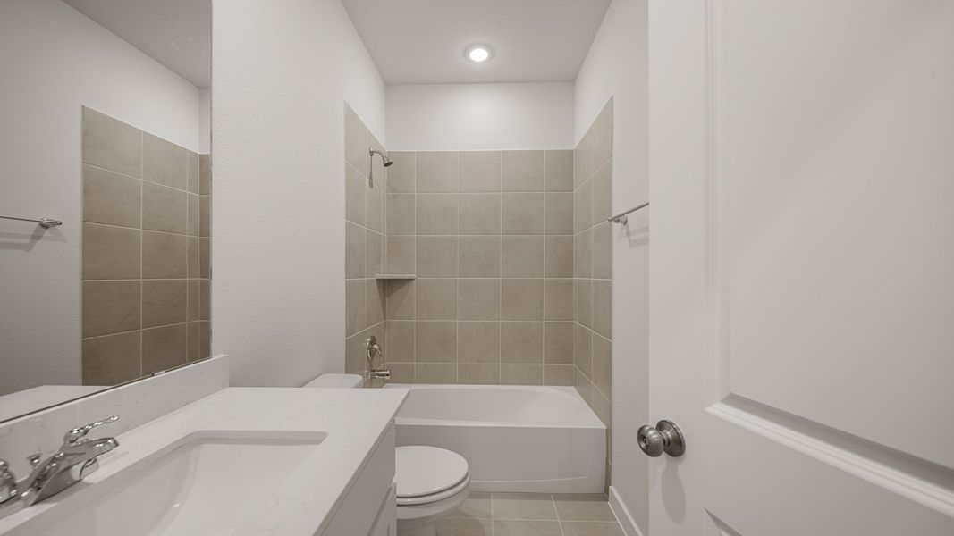 A bathroom with a tub sink and toilet.