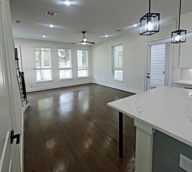 Looking back from kitchen to spacious living with multiple windows