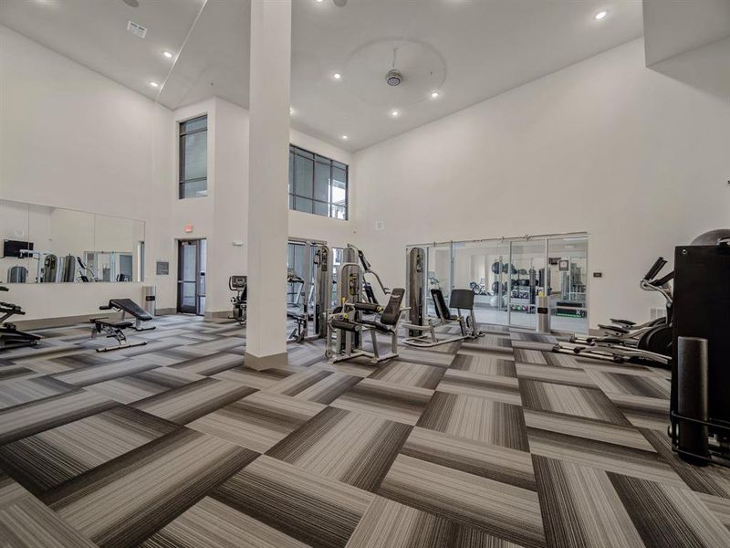 Workout area featuring carpet flooring, a towering ceiling, and recessed lighting Workout area featuring carpet flooring, a towering ceiling, and recessed lighting