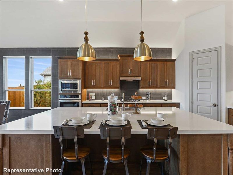 Kitchen with a kitchen bar, backsplash, a kitchen island with sink, appliances with stainless steel finishes, and recessed lighting Kitchen with a kitchen bar, backsplash, a kitchen island with sink, appliances with stainless steel finishes, and recessed lighting