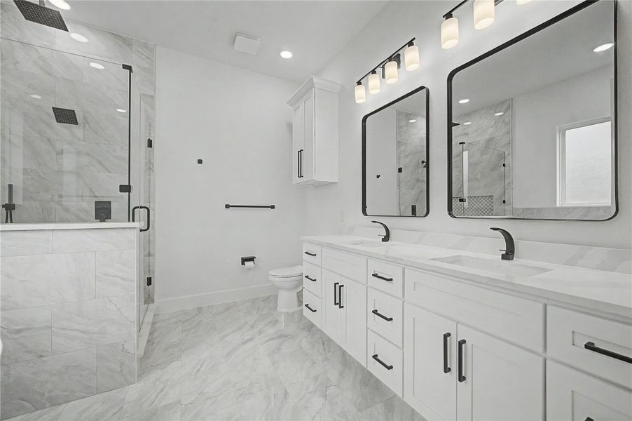 Dual-sink vanity with modern black fixtures, framed mirrors, and generous cabinet storage.