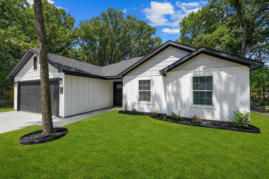 Contemporary exterior featuring white board and batten siding and black trim accents Contemporary exterior featuring white board and batten siding and black trim accents