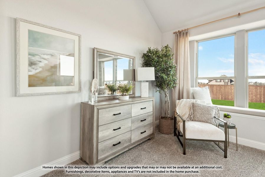Bedroom with vaulted ceiling, gray dresser with mirror, accent chair, and large windows overlooking backyard Bedroom with vaulted ceiling, gray dresser with mirror, accent chair, and large windows overlooking backyard