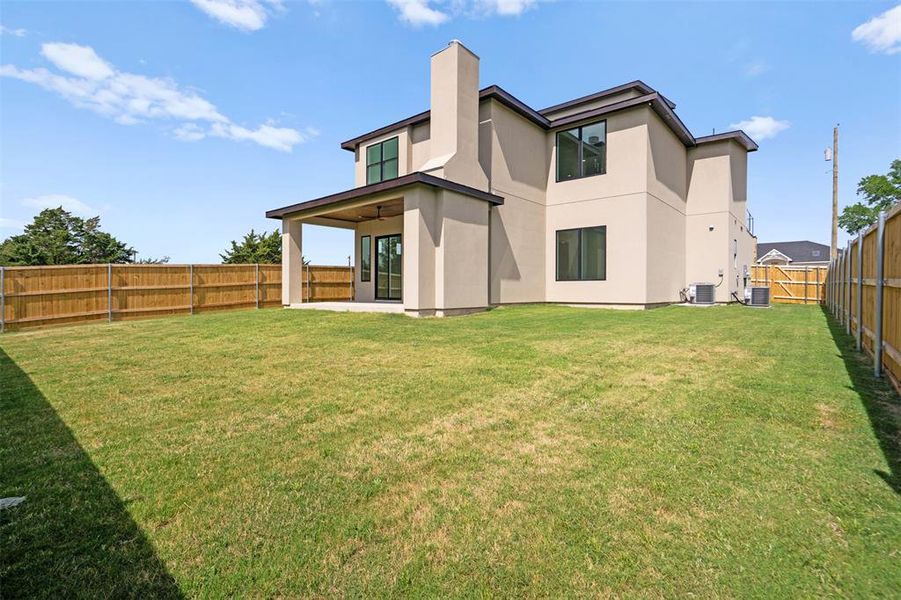 The property features an extensive lawn area, a covered patio with a ceiling fan, and a privacy fence enclosing the yard The property features an extensive lawn area, a covered patio with a ceiling fan, and a privacy fence enclosing the yard