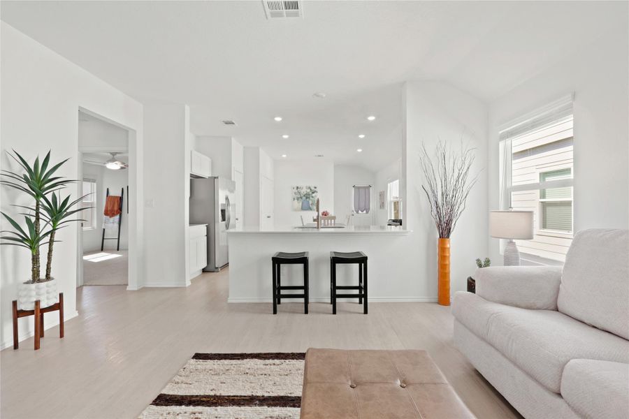 The modern kitchen serves as the home's central hub, featuring a large breakfast bar island and a clutter-free contemporary aesthetic that flows perfectly into the dining area.