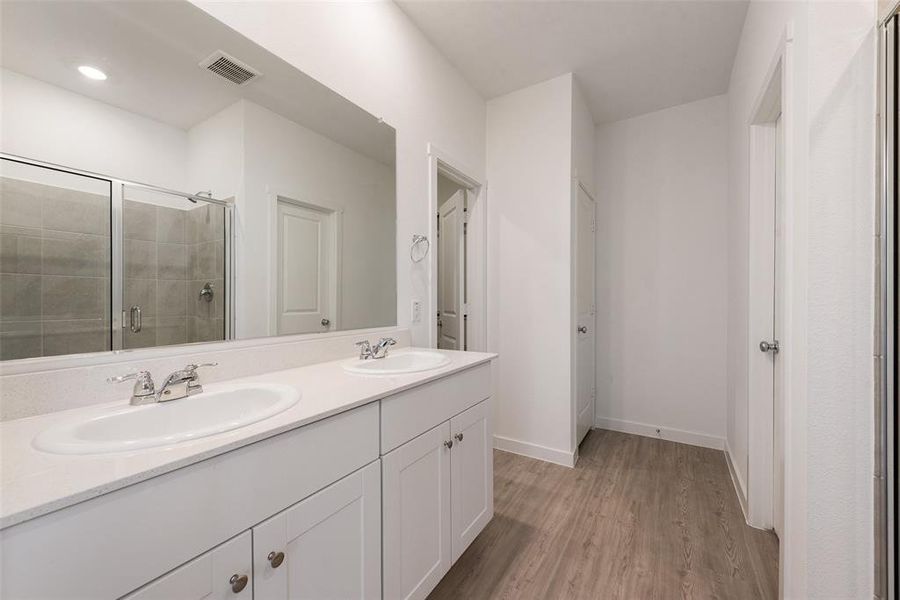 Bathroom with a shower with door, vanity, and hardwood / wood-style flooring