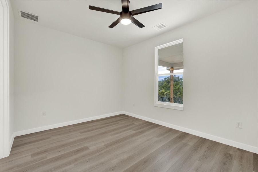 Empty room with light wood-type flooring and a ceiling fan