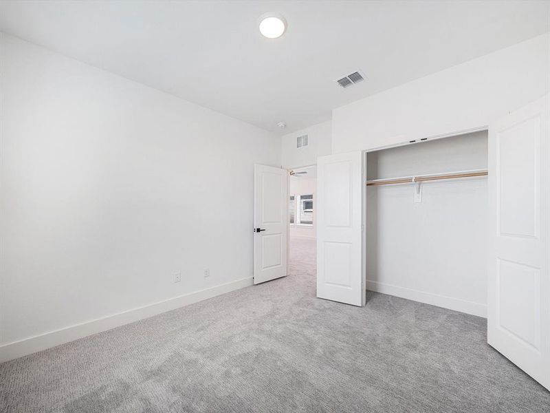 Unfurnished bedroom with light colored carpet and a closet