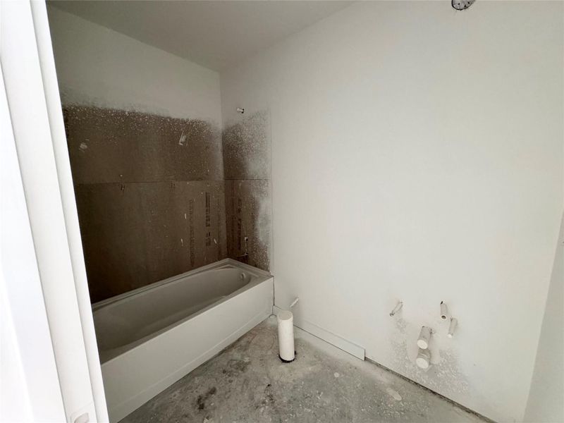 Bathroom with concrete floors and shower / tub combination