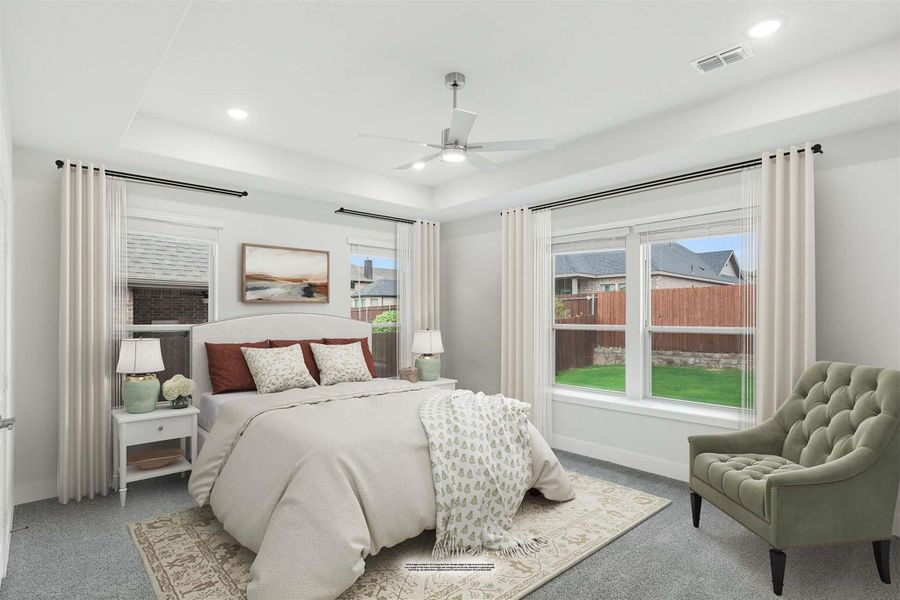 Bedroom with tray ceiling, ceiling fan, carpet flooring, and large windows with backyard view