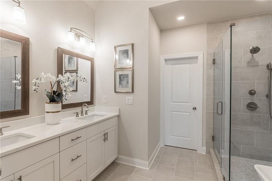 The spa bath has elegant quartz counter tops.