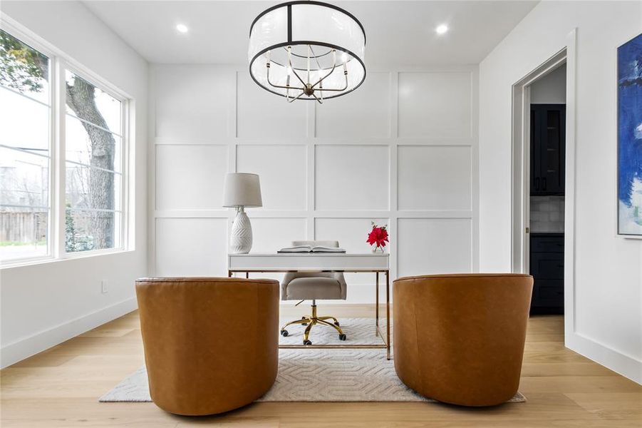 Office space with a healthy amount of sunlight, light wood-type flooring, and a chandelier