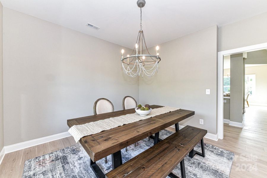 Formal Dining Room features custom light fixture & LVP floors!