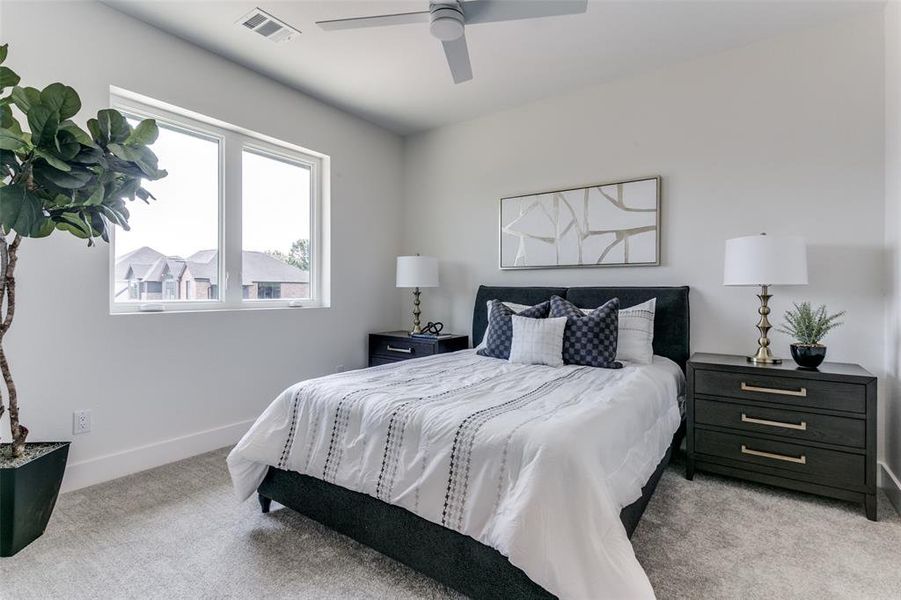 Carpeted bedroom featuring ceiling fan