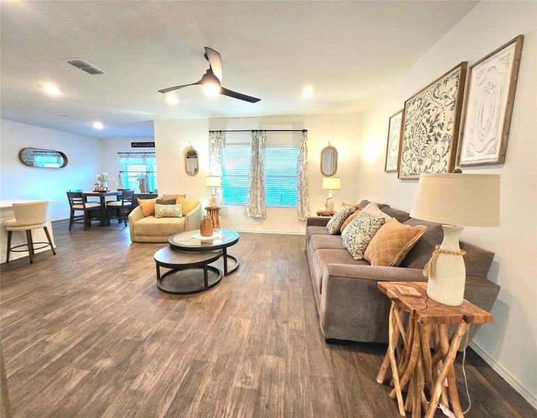 Open-concept living space with wood-finish flooring, recessed lighting, and a contemporary ceiling fan