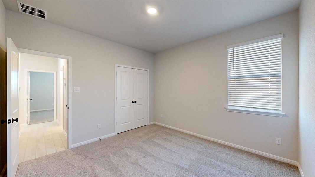 Unfurnished bedroom featuring light colored carpet and a closet