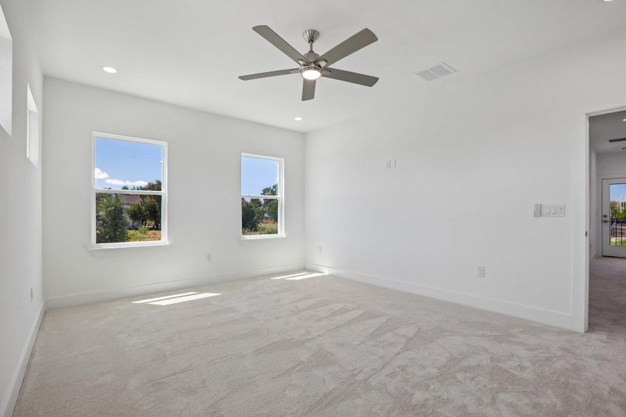 Soft carpeting underfoot and multiple windows overlooking the greenery define this serene room.
