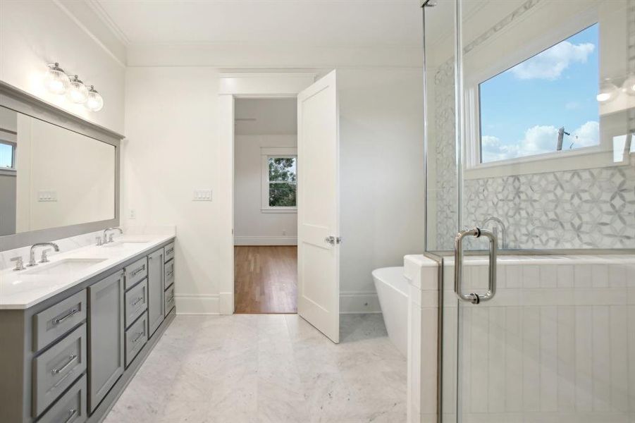 Welcome to the primary bath, where the floors are Chevron marble flooring.