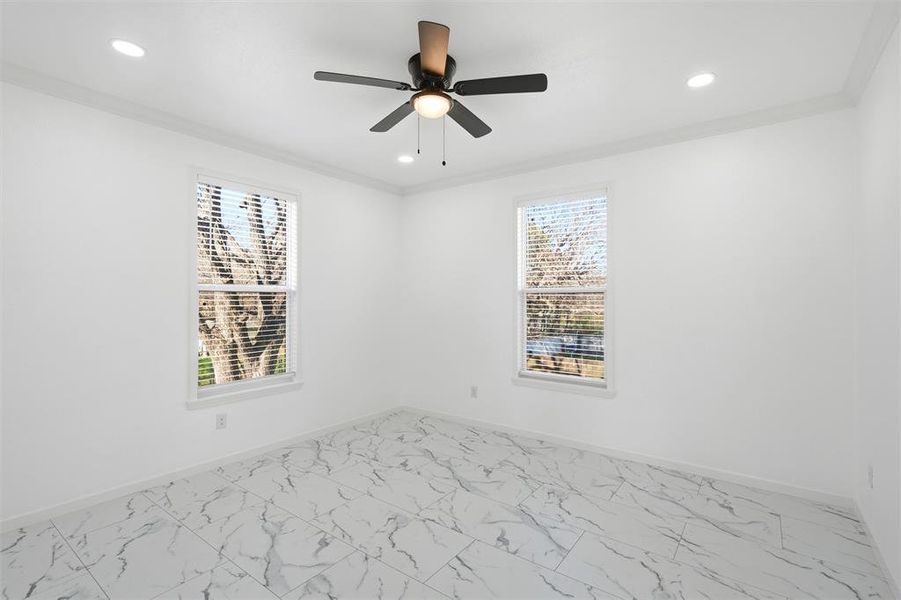 Spare room featuring light marble finish flooring, crown molding, plenty of natural light, ceiling fan, and recessed lighting Spare room featuring light marble finish flooring, crown molding, plenty of natural light, ceiling fan, and recessed lighting