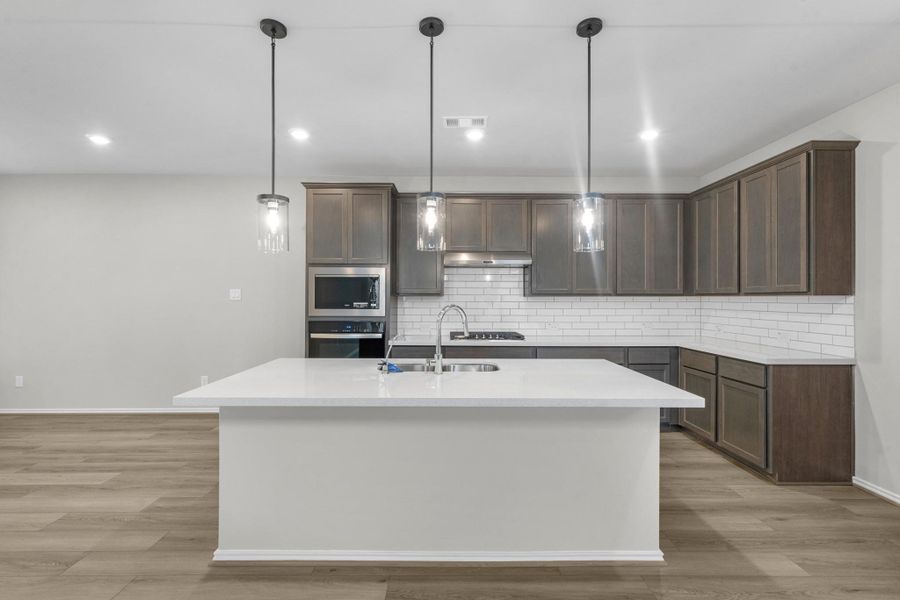 Quartz countertops & stainless steel appliances in the kitchen.