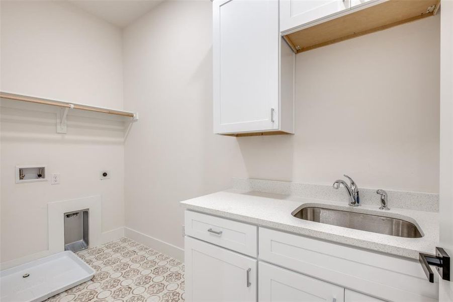 Clothes washing area featuring cabinets, electric dryer hookup, hookup for a washing machine, and sink