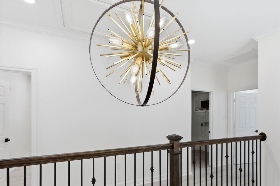 Striking gold starburst chandelier at the top of the staircase — a stunning second floor centerpiece.